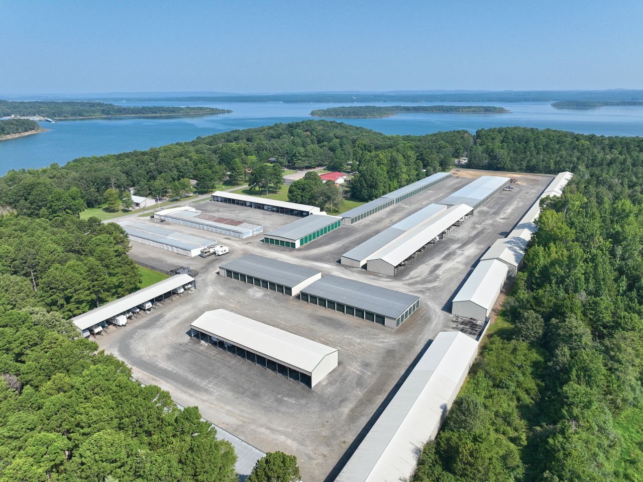 Aerial view of Golden Anchor Storage with storage buildings, covered parking, and nearby lake